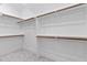 Bright walk-in closet with white walls, shelving, and wooden hanging rails for optimal storage at 3913 Cedar Knolls # 7, Youngsville, NC 27596