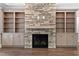 Detailed shot of the stone fireplace with built-in shelves and cabinets, set on hardwood flooring at 3923 Cedar Knolls Dr # 12, Youngsville, NC 27596