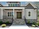 Inviting front porch with stone steps, black railings, and a beautiful wood door entrance at 3923 Cedar Knolls Dr # 12, Youngsville, NC 27596