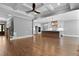 Open-concept living area with hardwood floors, a stone fireplace, and an adjoining kitchen at 3923 Cedar Knolls Dr # 12, Youngsville, NC 27596