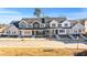 New construction townhomes with modern farmhouse style exteriors, paved sidewalks and young trees under a clear blue sky at 3935 Willow Gate Way, Knightdale, NC 27604