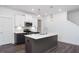 This contemporary kitchen features pendant lighting, stainless appliances, light cabinets and a gray island at 3935 Willow Gate Way, Knightdale, NC 27604
