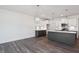 Open floorplan kitchen with stylish lighting, modern stainless appliances, white cabinets, and a gray center island at 3935 Willow Gate Way, Knightdale, NC 27604