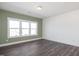 Large windows illuminate this living room, featuring wood-look flooring and neutral paint color at 3935 Willow Gate Way, Knightdale, NC 27604