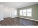 Bright living room featuring wood-look flooring and large windows, offering natural light and a view to the exterior at 3935 Willow Gate Way, Knightdale, NC 27604