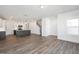 Open-concept living area with wood-look floors, modern lighting, and a view to the staircase and contemporary kitchen at 3935 Willow Gate Way, Knightdale, NC 27604