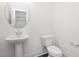 Stylish powder room with a pedestal sink, round mirror, and modern fixtures for guests' convenience at 3935 Willow Gate Way, Knightdale, NC 27604
