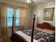 Bedroom with a wooden four-poster bed and floral quilt at 404 W Ninth St, Siler City, NC 27344