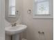 Stylish powder room with a pedestal sink, modern fixtures, and ample natural light, creating a fresh ambiance at 5302 River Reach Dr, Raleigh, NC 27616