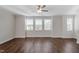 Spacious living room with new hardwood floors, modern ceiling fan and large windows at 5302 River Reach Dr, Raleigh, NC 27616