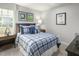 Cozy bedroom with plaid bedding, sports-themed art, and wood nightstand at 600 Mohinda Way, Willow Springs, NC 27592