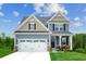 Two-story house with gray siding, white garage door, and landscaping at 600 Mohinda Way, Willow Springs, NC 27592