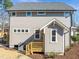 Side exterior view shows the siding, windows and a small wooden porch leading to a door at 713 Heidelberg St, Durham, NC 27704