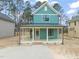New construction home with a large front porch and teal siding at 715 Heidelberg St, Durham, NC 27704
