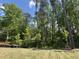 Large, level backyard with young trees planted and surrounded by mature woods offers an inviting, nature-filled setting at 752 Portland Rose Dr, Knightdale, NC 27545