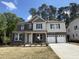 Two-story home featuring a stone and siding exterior with a two-car garage and manicured front lawn at 752 Portland Rose Dr, Knightdale, NC 27545