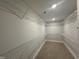 Spacious walk-in closet with wrap-around shelving and carpeted flooring at 752 Portland Rose Dr, Knightdale, NC 27545