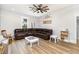 Spacious living room with brown leather sofa, light walls, and a ceiling fan providing a cozy and welcoming space at 1006 W Broad St, Dunn, NC 28334