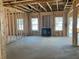 Unfinished Living Room showcasing exposed framing and a fireplace at 116 Black Walnut Dr # 203, Garner, NC 27529