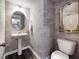 Powder room with pedestal sink, patterned wallpaper, and oval mirror at 1185 Atterlee Ln, Graham, NC 27253