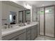 Bathroom features a walk-in shower with glass door, double sink vanity with quartz countertop and a large mirror at 1228 Hardin Hill Ln, Knightdale, NC 27545