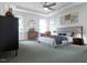 This primary bedroom has a tray ceiling, a ceiling fan, windows, accent furniture and decor at 1228 Hardin Hill Ln, Knightdale, NC 27545