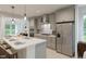 Well-lit kitchen with an island, stainless steel refrigerator, and modern light fixtures at 1228 Hardin Hill Ln, Knightdale, NC 27545