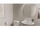 Modern bathroom with a white sink, toilet and round mirror at 1279 Willow Tree Way, Graham, NC 27253
