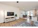 Open living room features hardwood floors, a large TV, and access to the kitchen and dining area at 1609 Mallard Trace Dr, Wendell, NC 27591