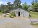 Horse barn exterior featuring a rustic wood structure with sliding doors and ample space at 265 Verde Rd, Apex, NC 27523