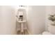 Modern powder room featuring a pedestal sink, decorative mirror, and adjacent toilet at 343 Foster St, Burlington, NC 27217