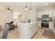 Open concept kitchen with white cabinets, stainless steel appliances, and island overlooking the living area at 343 Foster St, Burlington, NC 27217
