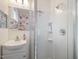 Bathroom with a white vanity, shower, and flower pattern wallpaper at 497 Turn Key Way, Pittsboro, NC 27312
