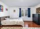 A well-lit bedroom boasting hardwood floors, a comfortable bed, a dresser, and two large windows at 497 Turn Key Way, Pittsboro, NC 27312