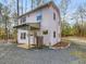 Charming two-story home featuring a covered porch and gravel driveway surrounded by mature trees at 497 Turn Key Way, Pittsboro, NC 27312