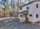 Charming two-story home with gravel driveway and a covered entry, nestled among tall trees in a secluded location at 497 Turn Key Way, Pittsboro, NC 27312
