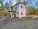 Charming two-story home nestled in a wooded setting, featuring a gravel driveway and a covered porch at 497 Turn Key Way, Pittsboro, NC 27312