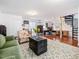 Spacious open-concept living area with ample seating, spiral staircase, and bright office space with multiple windows at 497 Turn Key Way, Pittsboro, NC 27312