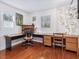 A dedicated office space featuring rich hardwood floors, large windows, and custom shelving for optimal organization at 497 Turn Key Way, Pittsboro, NC 27312