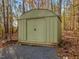 A durable, light-green metal storage shed offers secure outdoor storage amidst a backdrop of autumn trees at 497 Turn Key Way, Pittsboro, NC 27312