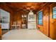 Cozy dining area with wood-paneled walls and a view of the kitchen at 5008 Rolesville Rd, Knightdale, NC 27545