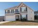 Two-story house with gray siding, white garage door, and landscaping at 1134 Aster Way, Burlington, NC 27215