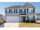 Two-story house with gray siding, white garage door, and landscaping at 1134 Aster Way, Burlington, NC 27215