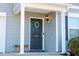 Dark-colored front door with wreath, columns, and porch light at 1134 Aster Way, Burlington, NC 27215
