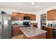 Island kitchen with stainless steel appliances and wood cabinets at 1134 Aster Way, Burlington, NC 27215