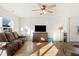 Living room showcasing a brown couch, wood floors, and a large TV at 1134 Aster Way, Burlington, NC 27215