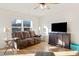 Living room with brown couch, wood floors, and a large TV at 1134 Aster Way, Burlington, NC 27215