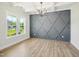 Dining room featuring a gray accent wall, a modern chandelier, and large windows overlooking the front yard at 18 Hewitt Woods Dr, Clayton, NC 27527