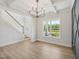 Elegant dining room with coffered ceilings, chandelier, and large windows showcasing landscaped front yard at 18 Hewitt Woods Dr, Clayton, NC 27527