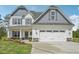Charming two-story home with a white exterior, gray accents and a two-car garage at 18 Hewitt Woods Dr, Clayton, NC 27527